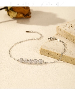Detail of silver S925 floral bracelet with sparkling zircons on elegant textured stone