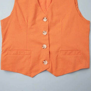 Detail of bright orange single-breasted cotton vest with V-neck and four textured buttons