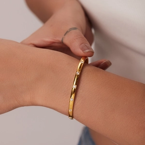 Détail d'un bracelet en acier inoxydable plaqué or 18K avec zircons blancs carrés