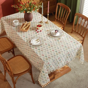 Frans vintage bloemen tafelkleed met witte franjes op een grote houten eettafel