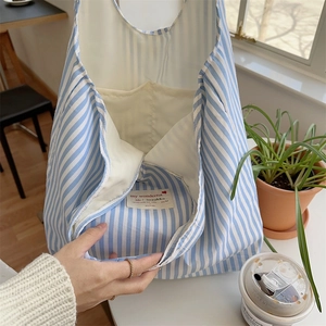 Detail view of large capacity blue striped canvas tote with inner pocket and woven label