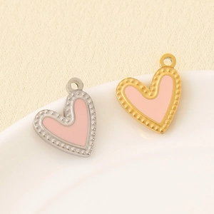 Pink heart pendants in gold and silver steel frames with beaded edges on a white dish