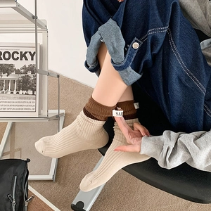 Detail of beige and brown color-block cotton crew socks with SALE label on the cuff