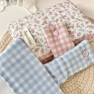 Detail of floral and checkered fabric book covers with cute resin snap button closures