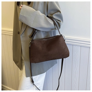 Deep brown suede shoulder bag with silver hardware worn on a grey blazer outfit