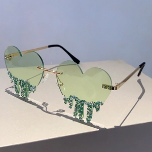 Macro shot of green heart-shaped rimless sunglasses with dripping crystal rhinestones