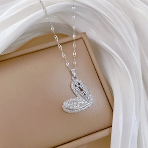 Macro shot of silver heart pendant necklace with micro-pave crystals on a warm jewelry box