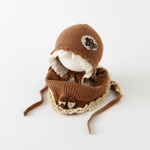 Détail de l'ensemble bonnet et écharpe tricotés pour bébé avec dentelle et fleurs vintage
