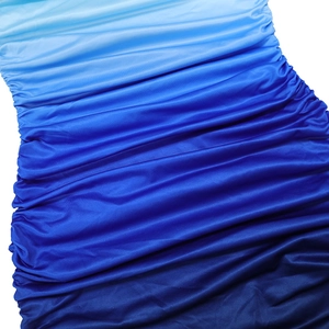 Close-up of gradient blue ruched fabric showing smooth spandex texture and pleated detail