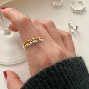 Detail of twisted knot design on S925 sterling silver rings worn on fingers
