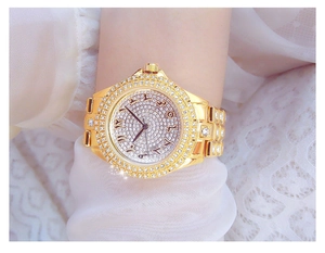 Détail d'une montre de luxe en or sertie de diamants et chiffres arabes au poignet