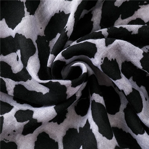 Macro view of leopard print scarf fabric showing soft texture and detailed pattern