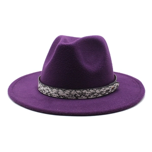 Detail of deep purple fedora hat featuring a snakeskin band and gold metal buckle