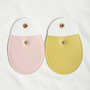 Detail view of pink and yellow PU leather jewelry pouches with white snap button closure