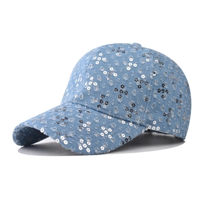 Detail of light blue distressed denim baseball cap with sequins and ripped vintage texture