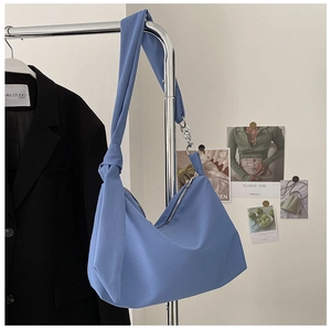 Close-up of Morandi blue canvas bag with unique knotted strap and metal chain detail
