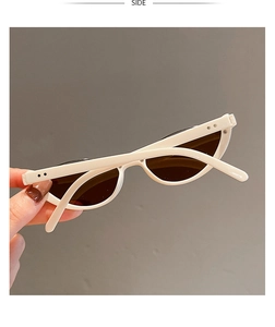 Side view of white cat-eye sunglasses with dark lenses and metal stud accents