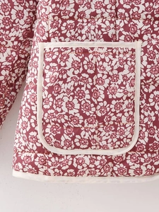 Detailed close-up of quilted floral cotton jacket featuring white trim and pocket stitching