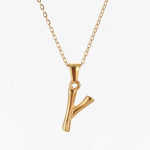 Close-up of golden stainless steel Y-letter pendant with bamboo texture and cross chain