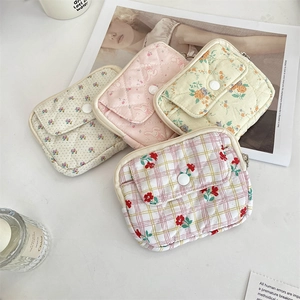 Flat lay of quilted floral card holders with snap pocket and zipper closure details