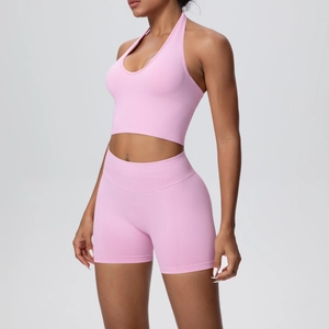 Close-up of pink seamless yoga set featuring halter neck top and ribbed high waist shorts