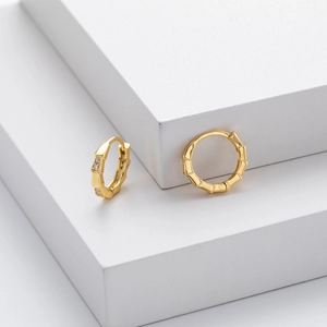 Macro detail of gold bamboo joint earrings with shimmering small zircon stones