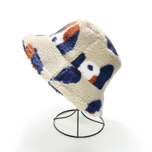 Detail view of plush sherpa bucket hat with colorful floral patterns on a display stand