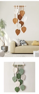 Dettaglio di decorazione murale in macramè con piume intrecciate color verde salvia