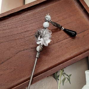Ink wash flower hair stick with resin petals and black pendant on a wooden tray