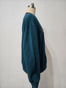 Detailansicht eines dunkelgrünen Sweatshirts mit Rundhalsausschnitt und Stickerei
