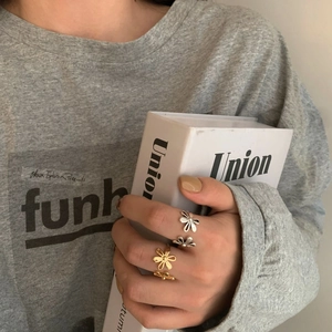 Minimalist flower open rings in gold and silver finish worn by a model in lifestyle shot