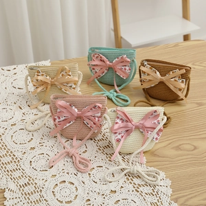 Détail de sacs bandoulière en paille avec des nœuds floraux en diverses couleurs pastel