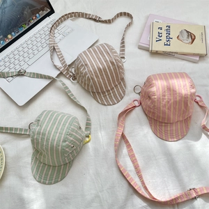 Detailed top view of baseball cap-shaped crossbody bags in various colorful stripe patterns