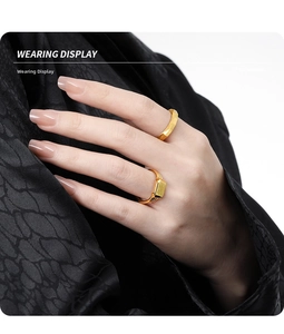Detail of faceted geometric and rectangular signet gold rings worn on person hand