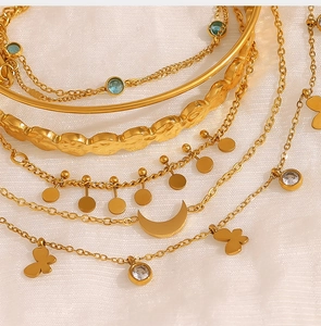 Macro shot of gold-plated layered bracelet set with moon pendants and blue gemstones