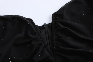 Détail du tissu en maille noire avec paillettes argentées et fermeture éclair