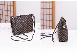 Detailed view of brown vintage printed crossbody bag with golden hardware and buckle
