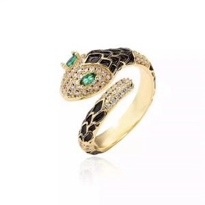 Gold snake ring with white cubic zirconia and black enamel scales on a white background