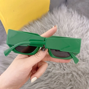 Detailed close-up showing the green rectangular frame and dark lenses of these sunglasses