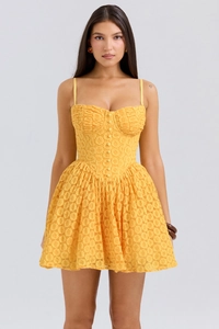Detail of yellow lace cocktail dress featuring a bustier bodice and button decor