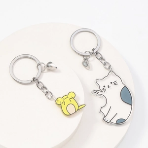 Detail of magnetic couple acrylic keychains with cat and mouse design forming a heart