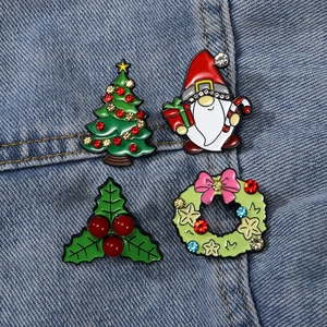 Set of four Christmas enamel brooches with Santa and tree on denim background