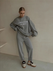 Women's grey knit two-piece set featuring oversized crewneck sweater and jogger pants