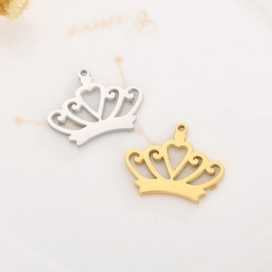 Exquisite gold and silver crown pendants with hollow heart design on a ceramic plate