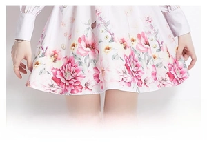 Détail de l'imprimé floral et des poignets plissés sur une robe courte vintage
