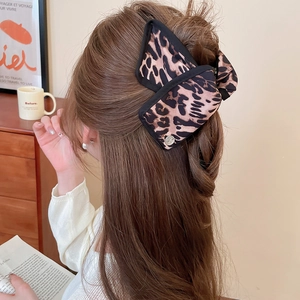 Close-up of leopard print fabric hair claw clip with lace edge on a ponytail