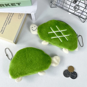 Detail view of green plush turtle coin purses with soft texture and white shell patterns