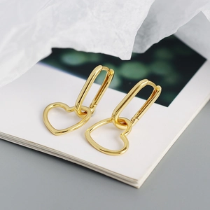 Detailed close-up of golden geometric heart hoop earrings with a polished metallic finish