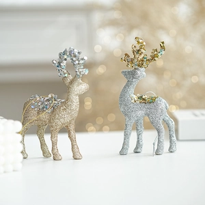 Detail of gold and silver glitter reindeer figurines with sequins and festive bokeh lighting