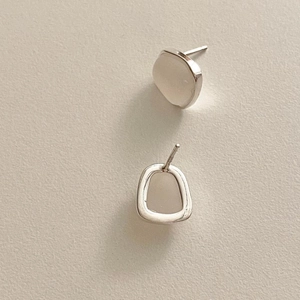 Close-up of minimalist 925 sterling silver square hoop earrings on a textured background